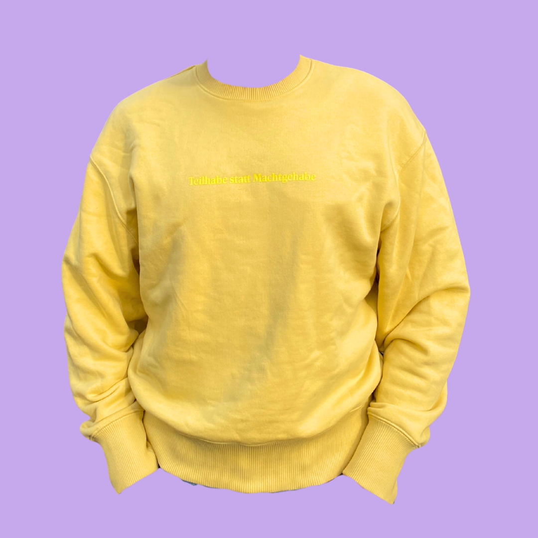 Senffarbener Sweater mit hellgelbem Print "Teilhabe statt Machtgehabe"