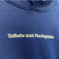 Dunkelblauer Hoodie mit hellgelbem Print "Teilhabe statt Machtgehabe"